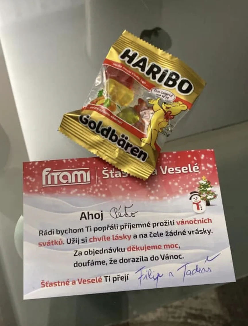 Vánoční kartička Fitami s ručně napsaným oslovením a podpisy Filipa a Tadeáše, doplněná balíčkem Haribo.